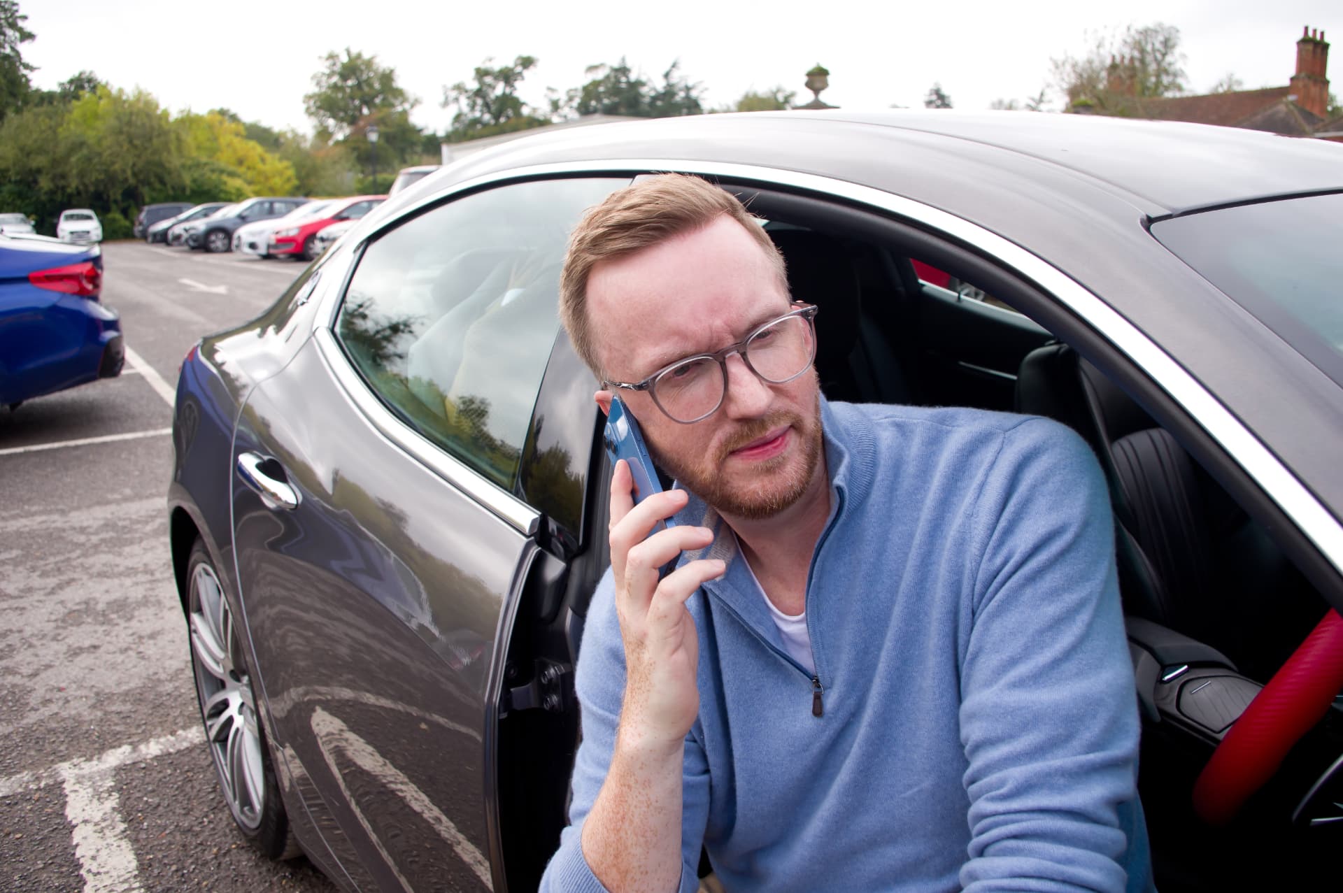 Dan taking a courtesy call from the driver's seat of the grey Maserati Ghibli