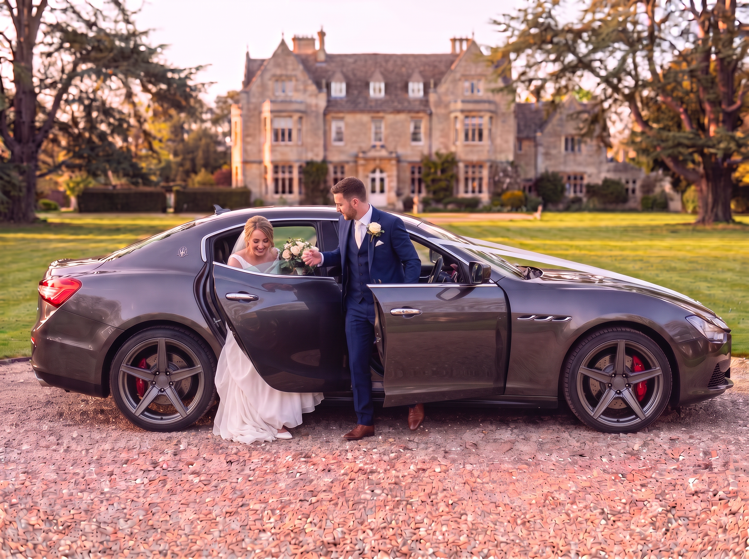 Bride and groom stepping out of the Maserati at a country house
